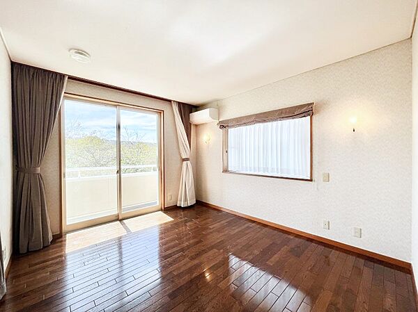 ウォークインクローゼット付きの洋室。バルコニーから入る明るい陽光が部屋全体を明るく照らします。