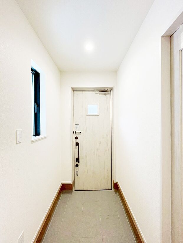 小窓から陽光を感じられる玄関