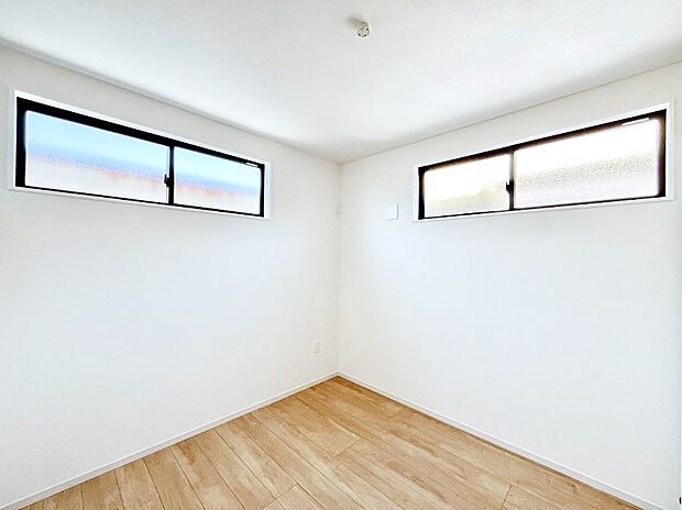 天井近くに横長の窓。柔らかい光が入り、ナチュラルで落ち着いた雰囲気の寝室。