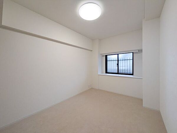 【洋室1】約6.1帖。出窓付きで採光がとれる室内です。