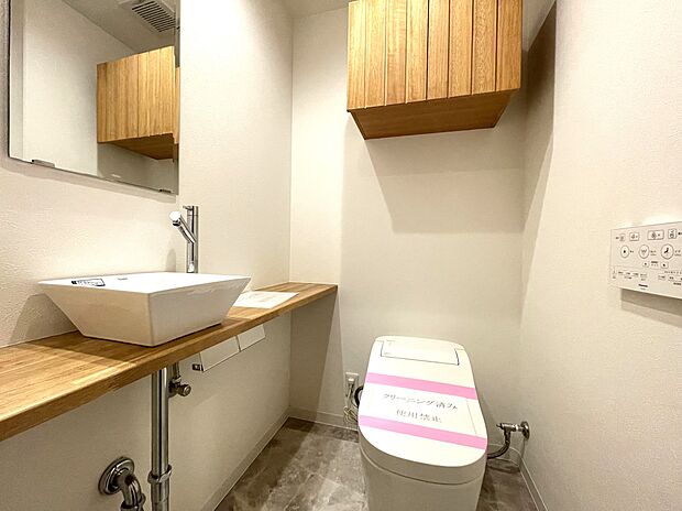 すっきりとしたデザインで木のぬくもりが感じられ、落ち着ける空間です。トイレもうれしいウォシュレット機能付きです。吊戸棚も設置されており、ミラーと便利な専用手洗いスペースも付いています。