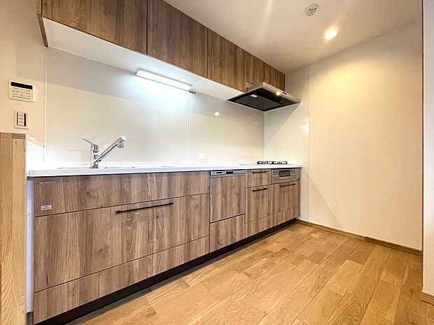 ナチュラルテイストなシステムキッチンは壁付けタイプで、リビングダイニングのスペースを広くフレキシブルに活用でき、お料理にも集中できます。ビルトイン食器洗浄乾燥機付きで、家事の負担軽減も期待できます。