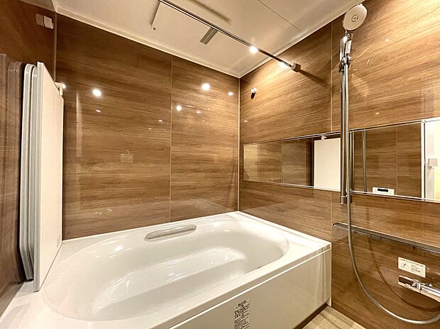 光沢感のあるウッド調パネルの落ち着いた内装で、1620サイズのゆったりとしたリラックス空間となっています。大型のシャワーヘッドやワイドミラーを備えています。浴室換気乾燥機付きで、バスタイムも快適です。