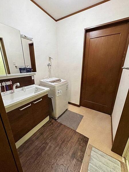 収納付きの洗面化粧台を備えた、ゆとりある洗面室