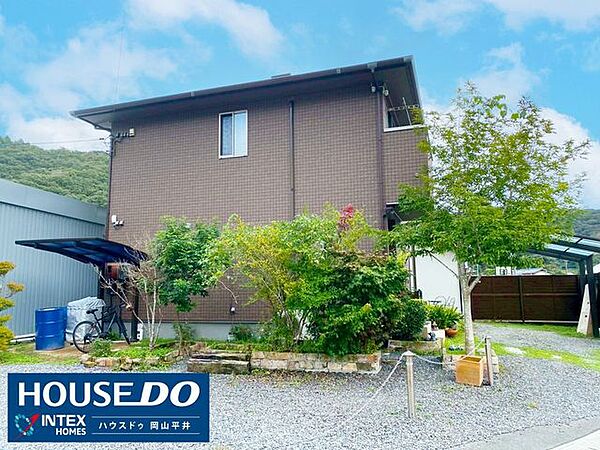 【温かみのある外観】落ち着いた色合いのブラウンが、周囲の緑と調和して温かい雰囲気を醸し出しています。家庭菜園なども楽しめる、緑豊かなお庭も魅力的ですね。