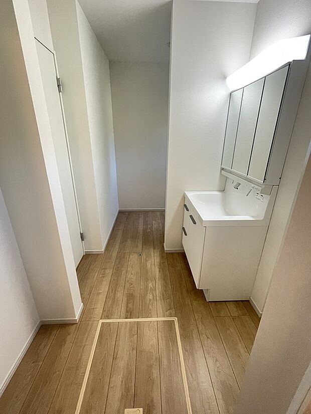 洗面室 奥部分は階段下を利用したリネン庫