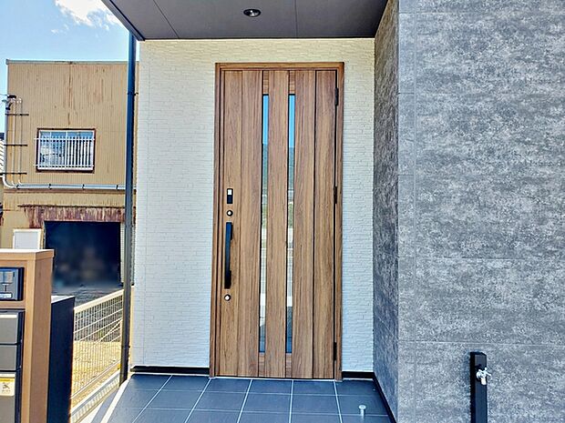 木目のデザインがぬくもりを感じさせてくれるシンプルなデザインの明るい玄関です。 