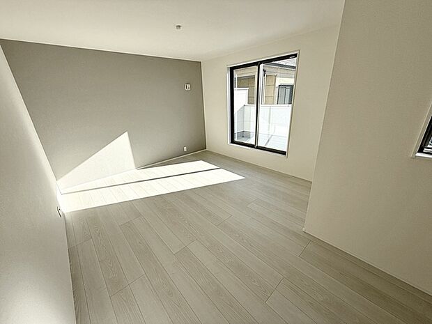 【洋室9.25帖】落ち着いた色味のアクセントクロスを壁の一部に使うと、とても落ち着いた空間になります。 