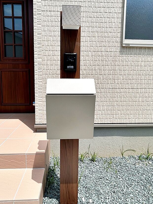 玄関前には一体型で場所を取らない、お洒落なカメラ付インターホン・ポストがあり表札も付けることが可能