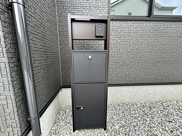玄関前には一体型で場所を取らない、お洒落なカメラ付インターホン・ポストがあり表札も付けることが可能