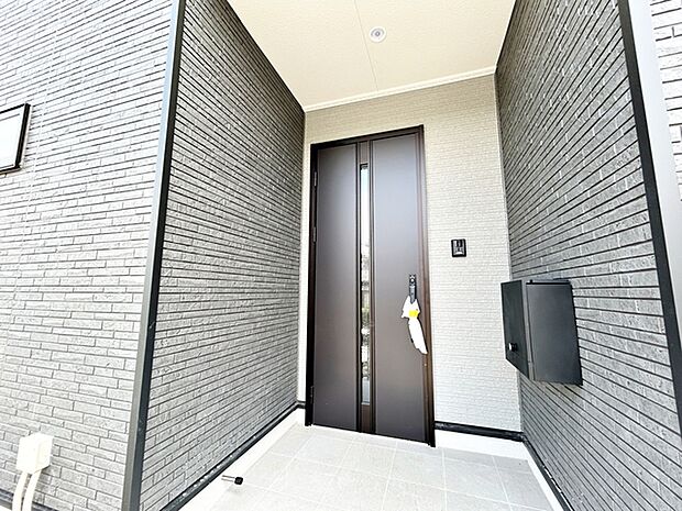 【玄関】 庇が広く、雨の日でも濡れにくい玄関ポーチです。玄関前で傘の開け閉めがしやすく、荷物が多い日でも落ち着いて出入りできます。毎日の外出や帰宅を快適にしてくれる、使い勝手の良い玄関まわりです。