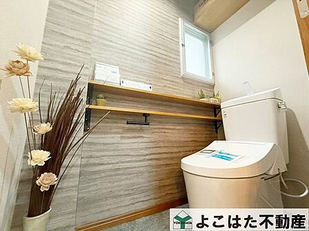 落ち着いた雰囲気の中にアクセントクロスを取り入れ、トイレ空間もおしゃれに演出。備え付けの収納棚もあり、トイレットペーパーや小物類の整理にも便利です。見た目も使い勝手も嬉しい、こだわりの空間です。