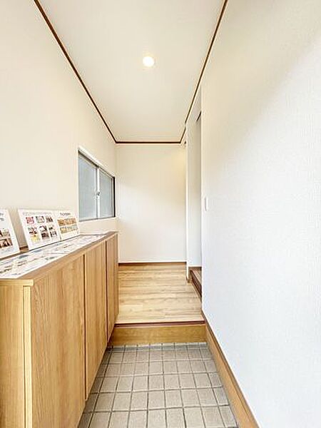 【内外装リフォーム完成済み】玄関（内部）の様子。天井や壁のクロスの張替え、下駄箱や照明の交換等を行いました。ちょっとしたインテリアやお荷物を置くスペースも確保されており、非常に使い勝手の良い空間です…