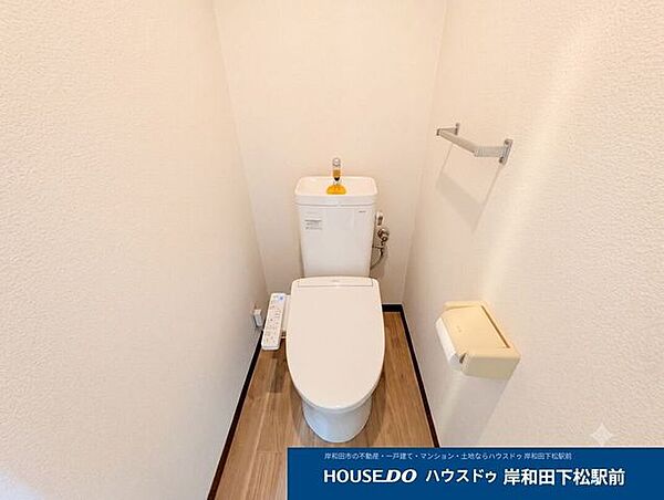 白を基調とした、シンプルで清潔感あふれるトイレ空間。心地よい温水洗浄便座（ウォシュレット）付きで、毎日快適に使用できます。タオル掛けやペーパーホルダーも完備された、使い勝手の良い設計です
