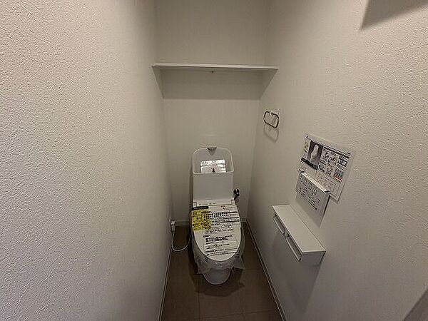 清潔感のある快適なトイレは、トイレットペーパーや掃除用品をすっきり収納できる便利な棚付きです