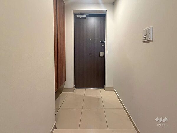 落ち着いた木目扉が印象的な玄関。隣にシューズボックスを備え、靴や小物をすっきり収納できる使い勝手の良い空間です。