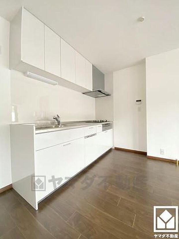 真っ白の清潔感のあるキッチン。キッチンは空間を有効活用できる壁付けタイプ。