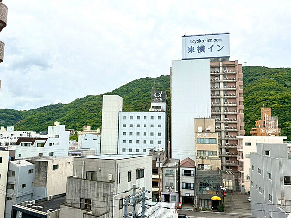 窓の向こうに広がる緑の山景が日常の癒やしに。街中立地ながら開放的な眺めを楽しめます。