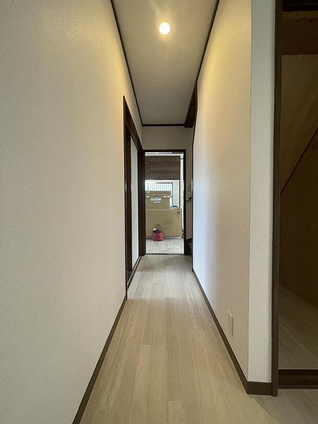 【リフォーム済】廊下は壁・天井のクロスの張替え、照明器具の交換を行いました。玄関はお家の顔となる部分、白いクロスの映える明るい空間に仕上げていきます。