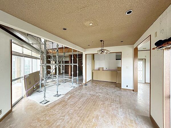 【リフォーム中】南向き約24帖のリビングの別角度写真です。天井・壁のクロスの張り替え、フローリングの重ね張り、耐震工事を行います。窓からの陽光が心地よく、家族団欒にぴったりの空間です。