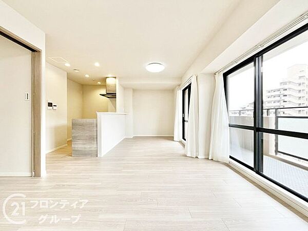 大きな窓から柔らかな陽光が降り注ぐ、開放感に満ちたリビングです。木のぬくもりを感じるフローリングが、家族みんなが自然と集まりたくなるような心地よい安らぎを醸し出します