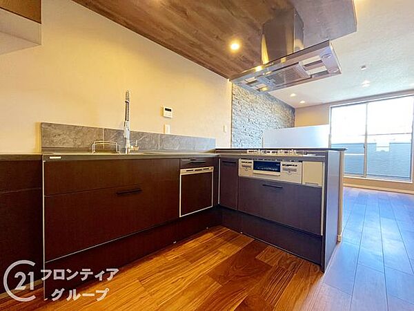 シックな木目調と石目調のタイルが調和した高級感あふれるキッチン。広々としたL字型で効率よくお料理を楽しめる設計となっています。食洗機も完備されており、日々の家事負担を軽減してくれます