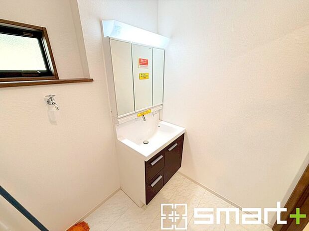 ~明るい洗面スペース~ ・窓から明るい陽が入り、気持ちよく朝の支度ができますね。 ・使い勝手の良い三面鏡タイプのシャワー付き洗面化粧台。鏡の裏に収納があるので洗面台周りもスッキリ。