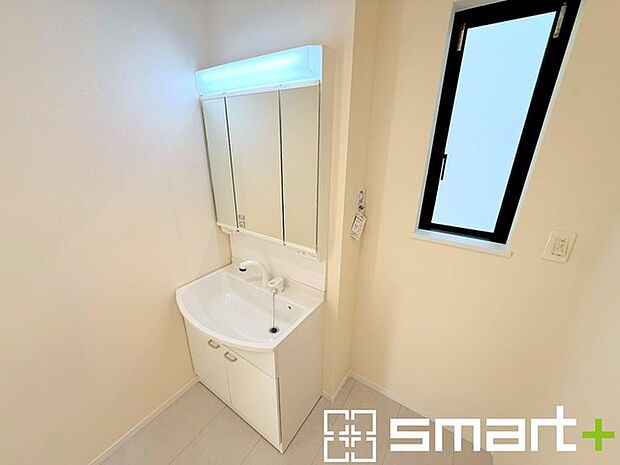 ~明るい洗面スペース~ ・窓から明るい陽が入り、気持ちよく朝の支度ができますね。 ・使い勝手の良い三面鏡タイプのシャワー付き洗面化粧台。鏡の裏に収納があるので洗面台周りもスッキリ。