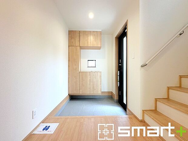 ～穏やかな陽が入る玄関～ ・窓に加えて玄関ドアのガラス部分からも穏やかな陽が入り、明るい玄関になります。 ・飾り棚としても演出できるコの字型のシューズボックスは大容量の収納力。