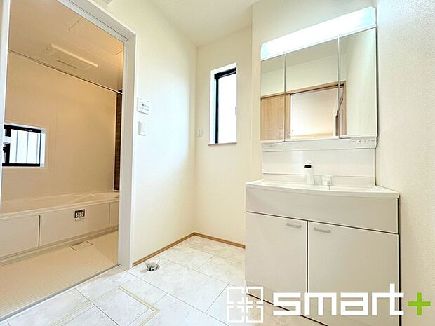 ～明るい洗面スペース～ ・窓から明るい陽が入り、気持ちよく朝の支度ができますね。 ・使い勝手の良い三面鏡タイプのシャワー付き洗面化粧台。鏡の裏に収納があるので洗面台周りもスッキリ。