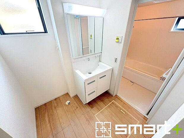 ～明るい洗面スペース～ ・窓から明るい陽が入り、気持ちよく朝の支度ができますね。 ・使い勝手の良い三面鏡タイプのシャワー付き洗面化粧台。鏡の裏に収納があるので洗面台周りもスッキリ。 