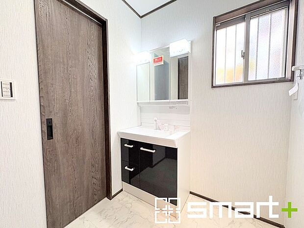 ～明るい洗面スペース～ ・窓から明るい陽が入り、気持ちよく朝の支度ができますね。 ・使い勝手の良い三面鏡タイプのシャワー付き洗面化粧台。鏡の裏に収納があるので洗面台周りもスッキリ。 