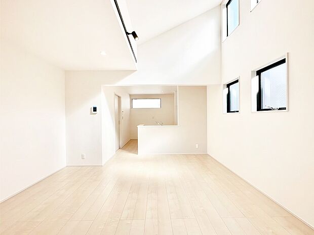 吹き抜けから明るい陽光が注ぎ、寛ぎの雰囲気に満たされるダイニング。