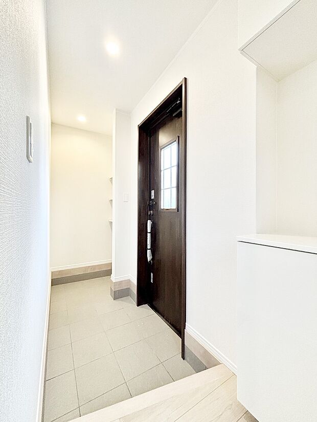 小窓から陽光を感じられる玄関