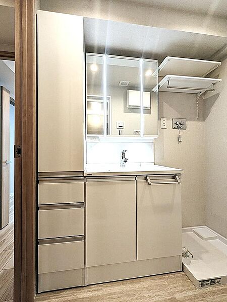 【洗面化粧台】使い勝手の良い大きな鏡と豊富な収納を備えた洗面化粧台。朝の身支度やヘアメイクがスムーズに行える、清潔感あふれる明るいパウダールームで快適な新生活を始められます。