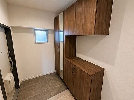 ※居住中の為、家具を消す画像処理を施しております。リフォーム済みの清潔感ある玄関。木目調のシューズボックスを備え、玄関まわりをすっきり整理できます。