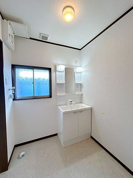 【リフォーム済】洗面脱衣室です。床はクッションフロア張替え、壁と天井のクロス張替、新品洗面台設置、照明交換でキレイに仕上げました。