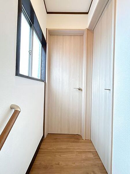 【リフォーム済】2階廊下です。天井・壁のクロスを張替え、永大産業製のフローリングを張替えました。照明も交換し、明るい印象に生まれ変わっています。