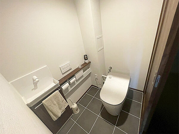 【トイレ】温水洗浄便座付きのトイレです。寒い時期でも暖かな便座で快適に使うことができます。リモコンが壁に設置され、操作しやすい仕様です。/2026年1月撮影