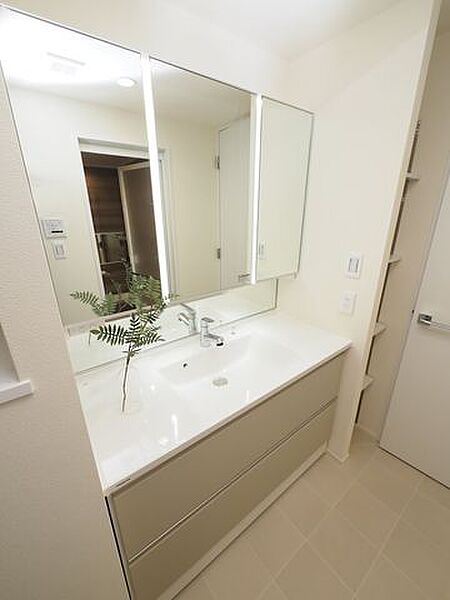 洗面台は三面鏡タイプ。いろいろな方向から確認ができるので大変便利です。鏡の後ろは収納スペースとなっており、ヘアケア用品や洗面用品などを収納することが出来るので洗面所まわりがスッキリします。