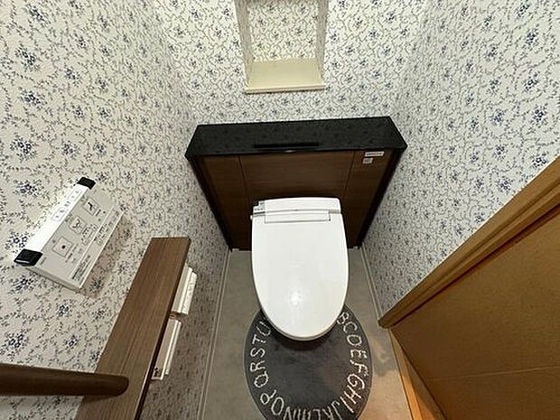 【トイレ】1年を通して快適に使用できる温水洗浄便座機能付きトイレです。見た目がすっきりとしているので、空間がより広く感じられます。背面のニッチ収納には、芳香剤などを設置できます。