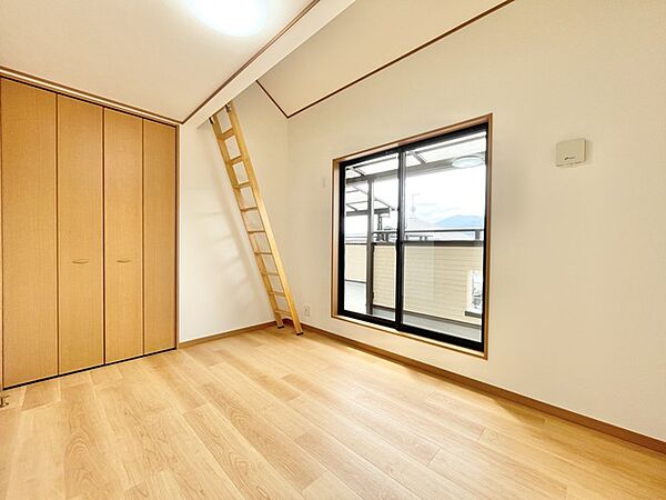 2階8帖の主寝室。広々としたバルコニーに面しており、天井には屋根裏収納があります。季節によって荷物を分けられますね