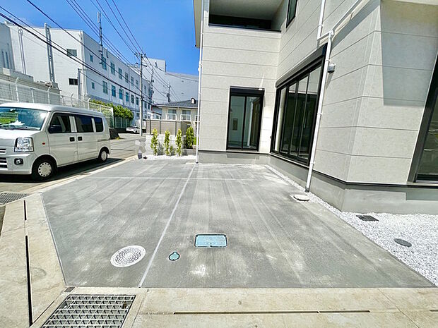 青空が広がる日、白壁とグレーのタイルが織りなすモダンな外観が、整然とした空間に溶け込み、都会的でありながらも落ち着いた佇まいを感じさせます