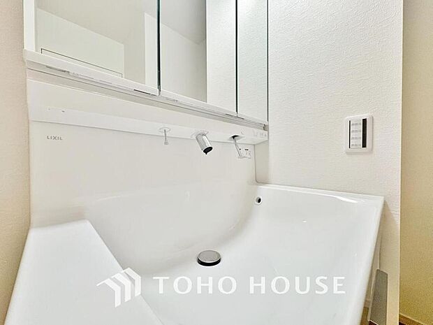 シャワー機能付きの洗面台にはワイドな三面鏡、使いやすい横長ボウル、収納と充実しています。