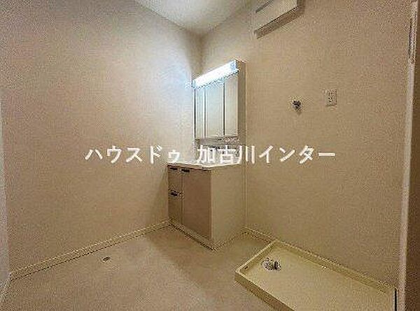 ゆとりある広さが確保された、清潔感あふれる洗面脱衣スペースです。機能的な三面鏡付き洗面化粧台に加え、洗濯機置き場もゆったりと配置されており、毎日の家事や身支度をスムーズに行えます。