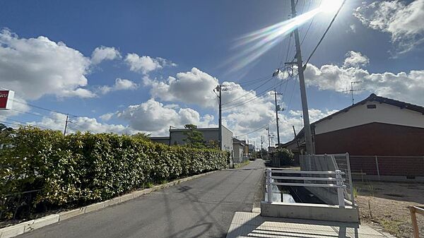 現地（R6.8）撮影大通りから一本入った閑静な住宅街オージー技研様の建物裏に位置します。植栽はいつもきれいに整備されています