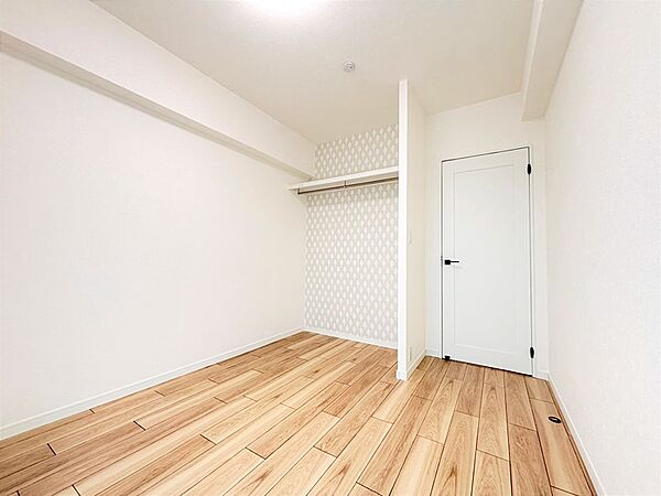 白を基調とした内装に、暖かみのある木目調のフローリングが映える居室です。デザインクロスがアクセントになり、明るく開放的な空間を演出します。