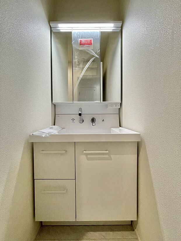 大きく見やすい三面鏡で清潔感ある洗面台は、身だしなみチェックや肌のお手入れに最適です。何かと物が増える場所だからこそ、スッキリと見映えの良い空間に拵えました。