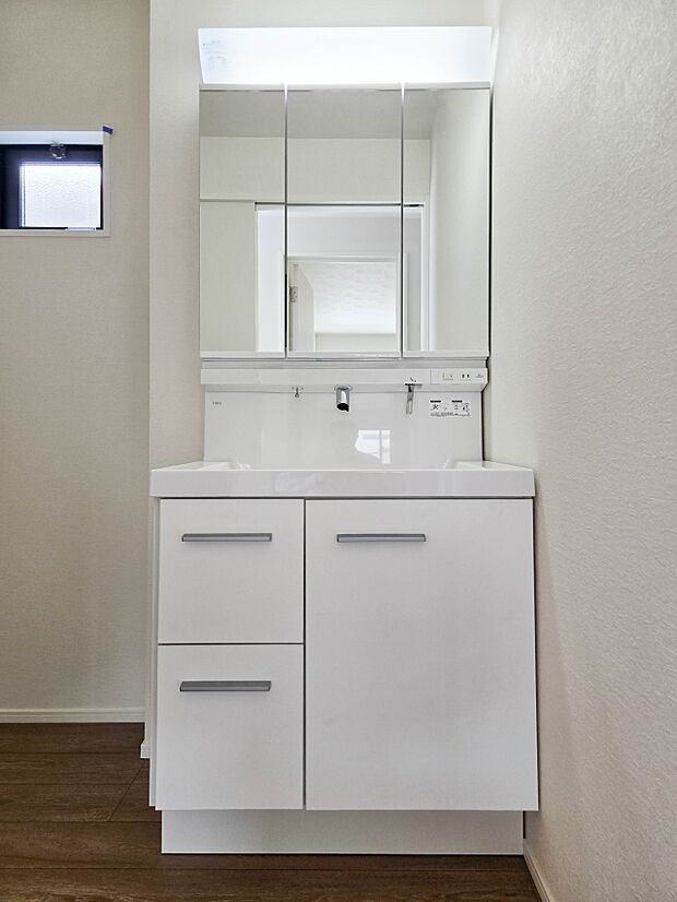 【洗面台】大きく見やすい三面鏡で清潔感ある洗面台は、身だしなみチェックや肌のお手入れに最適です。何かと物が増える場所だからこそ、スッキリと見映えの良い空間に拵えました。