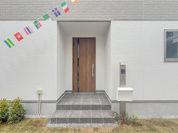 【玄関】玄関へ向かうまでのアプローチに漂う上質が期待感をもたせます。玄関は建物の顔。落着きを醸し出した自己主張が心に訴えてきます。